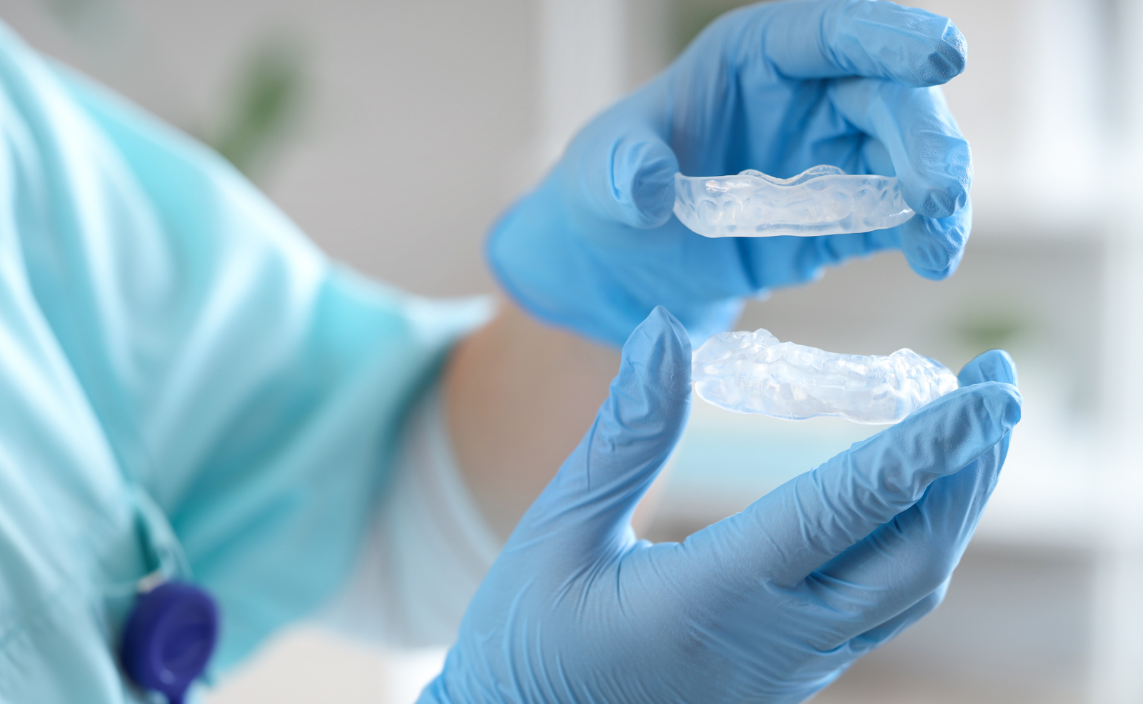 Imagen de las manos de personal sanitario mostrando una férula para el bruxismo personalizada