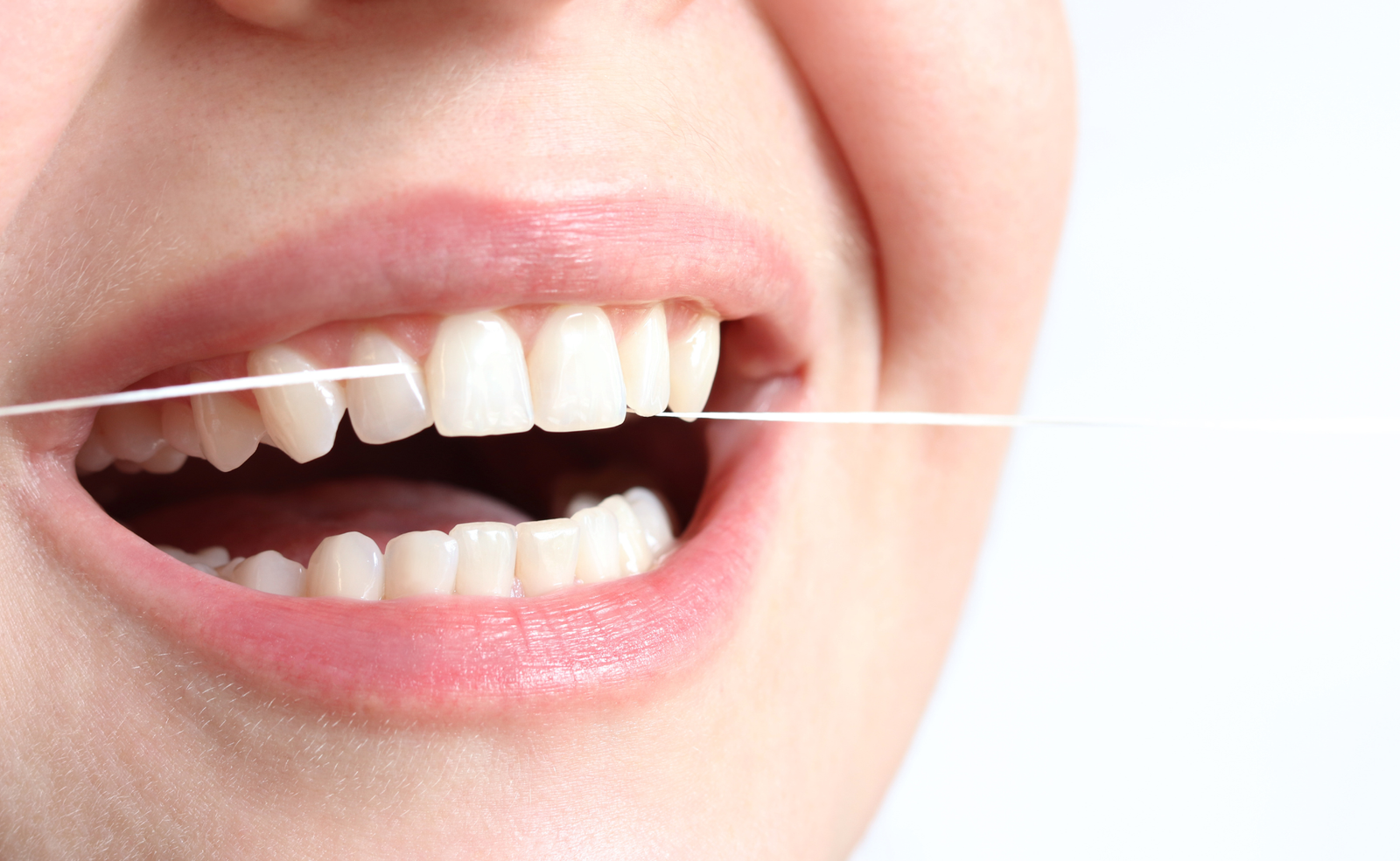 Mujer pasándose el hilo dental